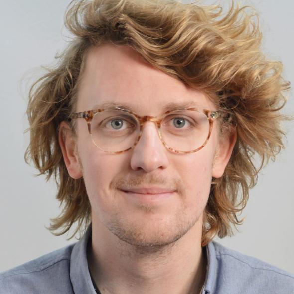 Image of man with wavy blond hair and glasses