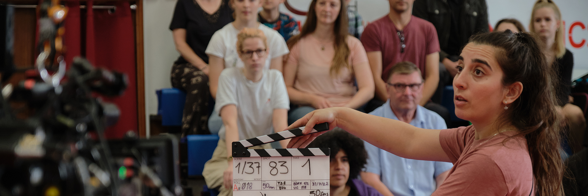 Student with clapperboard on set