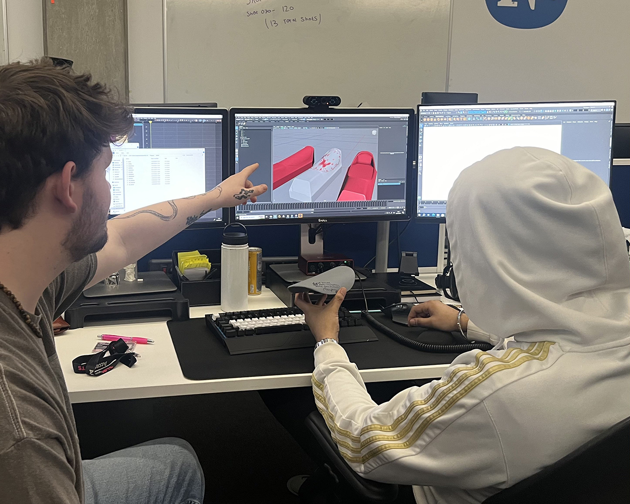 VFX students examining 3D printed pod lid.
