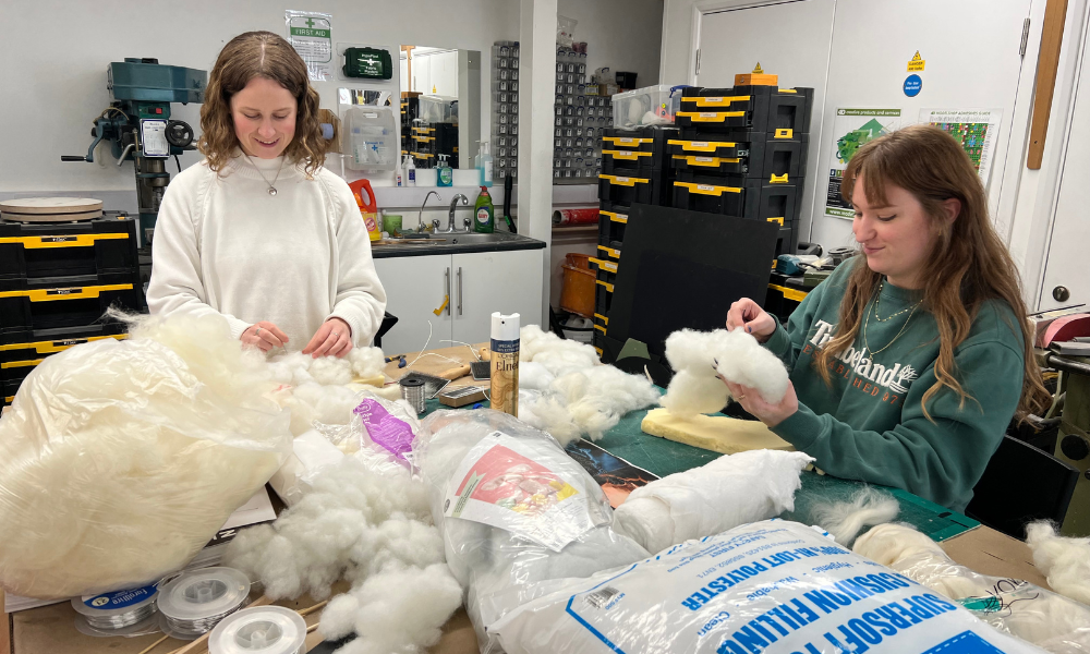two women making clouds from upholstery waddings
