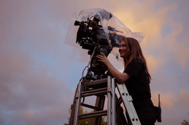 woman with camera with sky in background