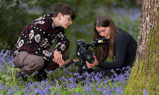 two people with camera filming macro flowers