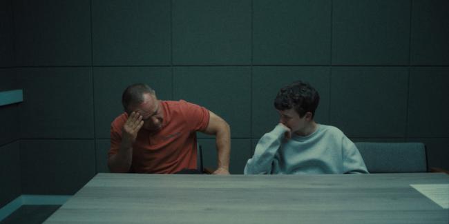 man and son sitting at a table in grey room