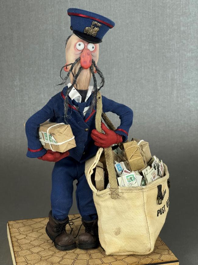 model of a postman with bag of parcels and letters