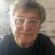 Image of man with grey hair and glasses looks towards camera