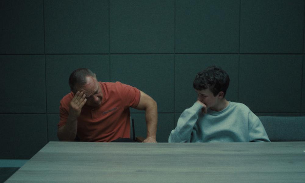 man and son sitting at a table in grey room