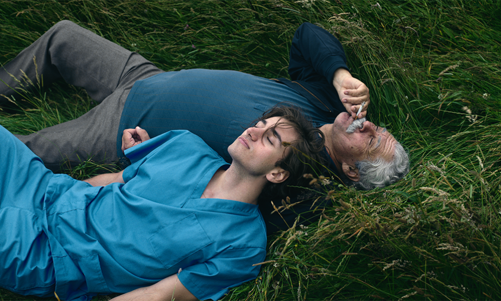 young and old man lying in the grass