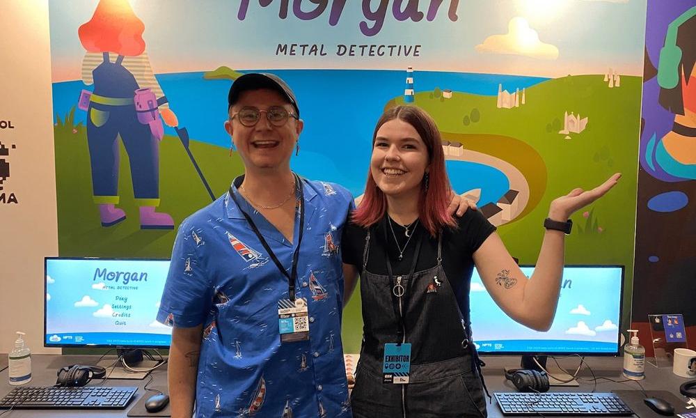 holly and harvey standing in front of game poster at EGX