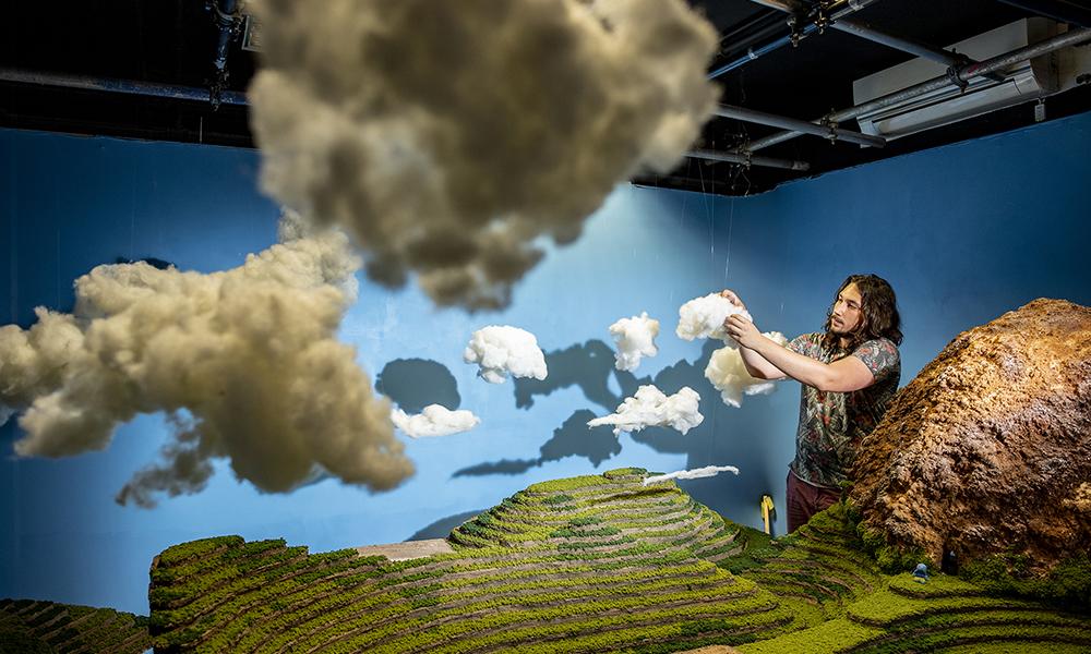 student on animation set with clouds and hill