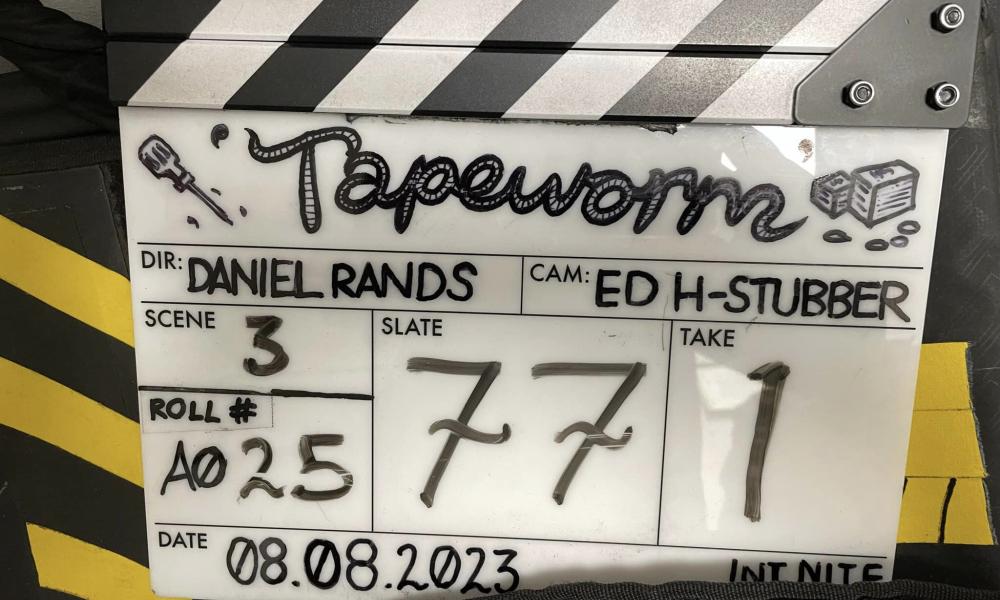 clapper board with film name tapeworm written in worm drawings