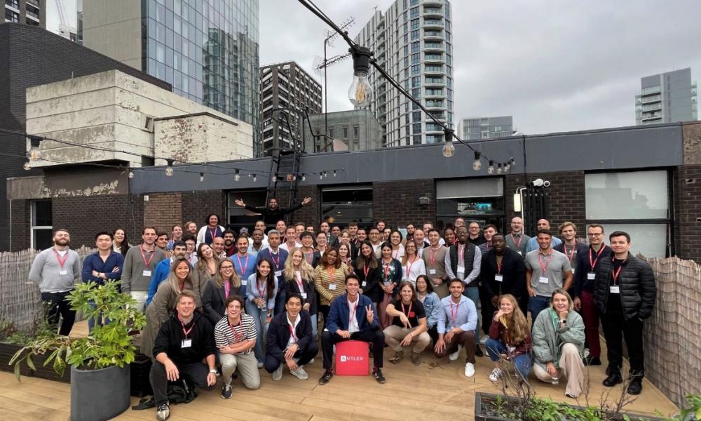 Large group of people outside building posing for photo