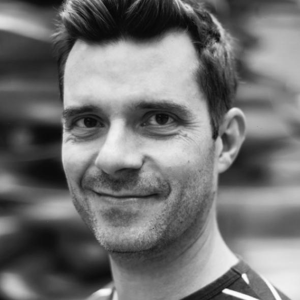 Black and white image of white man with short hair smiling