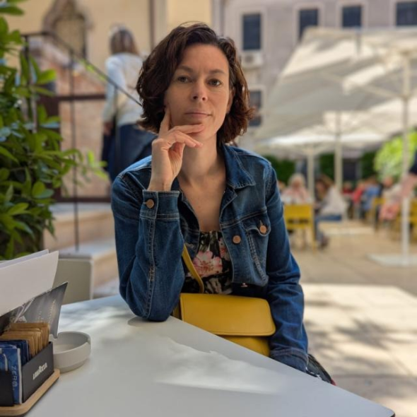 A women in a denim jacket sat at a table