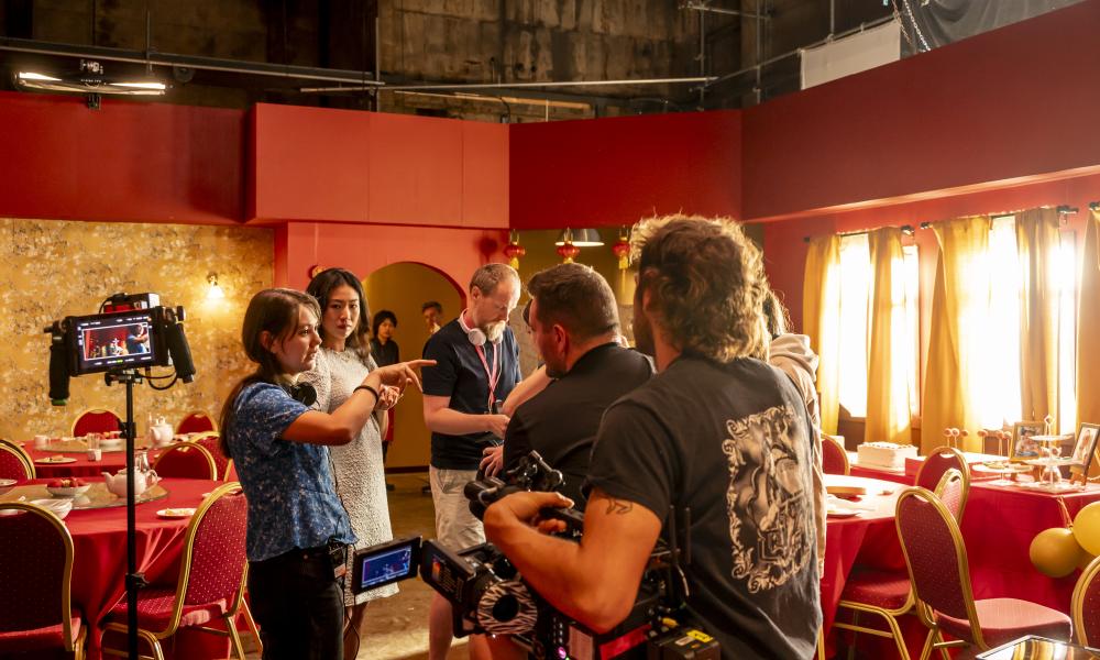 Behind the scenes of students filming a scene in a restaurant